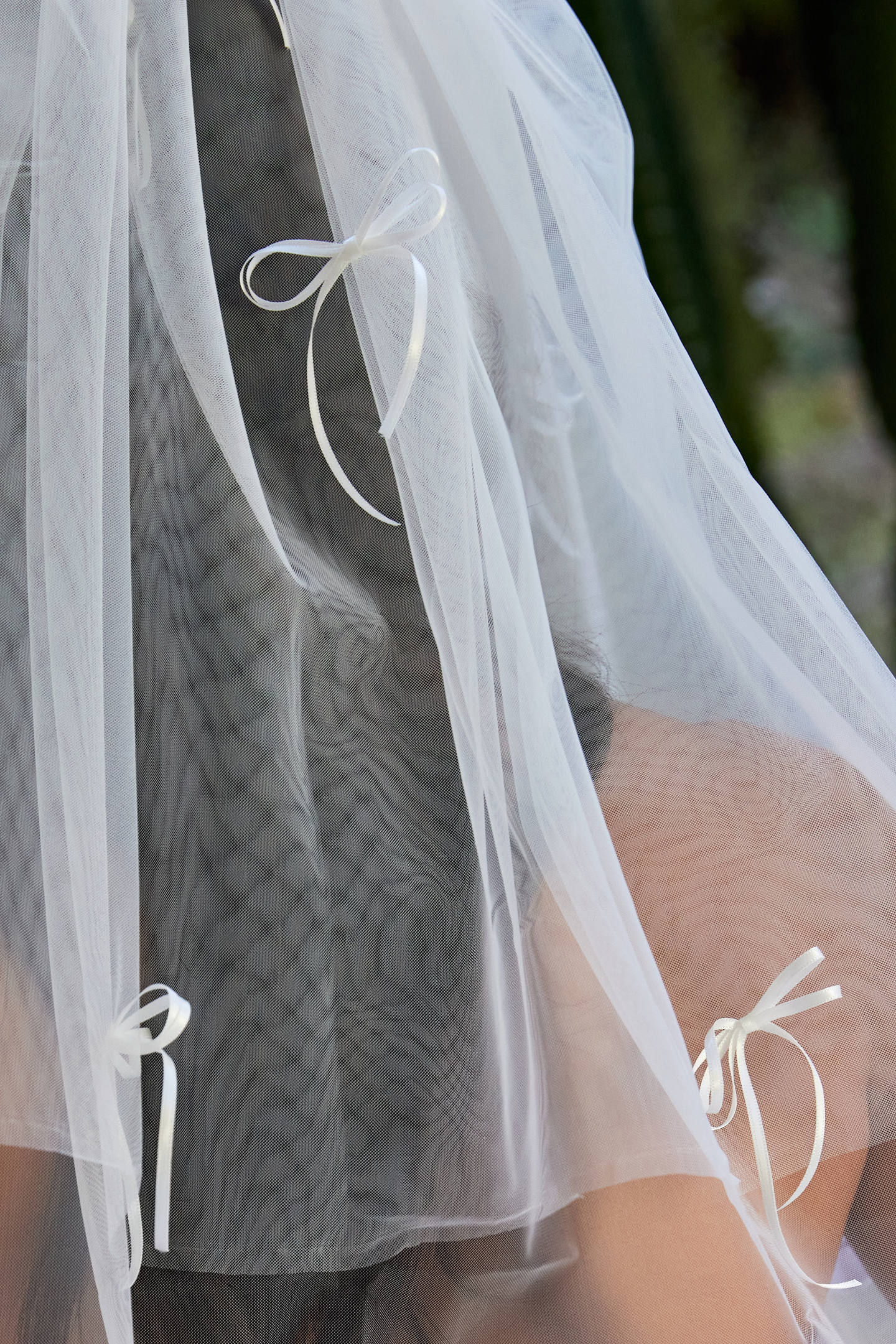 Woman wearing ALT’s Roma top, Margot bottom, Belle Bow veil. a white bridal bikini set, with cacti in the background. White tulle bridal veil with small bow details