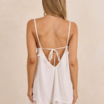 ALT's white Coco babydoll nightie, a close-up from behind of the personalized script embroidery and a garter at the thigh.