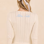 ALT's ivory Lark top seen from behind, personalized script embroidery below the neckline, over the matching Wren shorts.