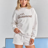 White Althea track short from the front, a white drawstring tied at the elasticated waist, worn under the Pia crew sweatshirt.