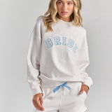 White Bride Pia crew sweatshirt from the front, BRIDE in blue-outlined varsity applique across the chest, worn with the Bride Althea track short.