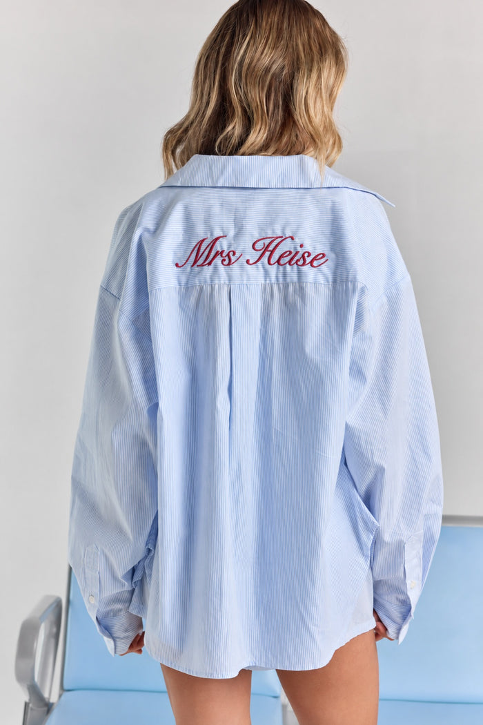 ALT's blue stripe Corinna button-up shirt from behind, with personalized embroidery across the back yoke and a center box pleat.