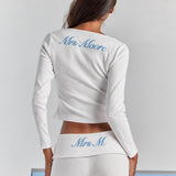 Closer view from behind of the white Frankie foldover ribbed pant, personalized embroidery on the fold-over waistband, under the Cleo long sleeve top.