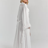 White Melita feather satin robe from a three-quarter back angle, with personalized embroidery at the upper back, the belt and a full feather hem.