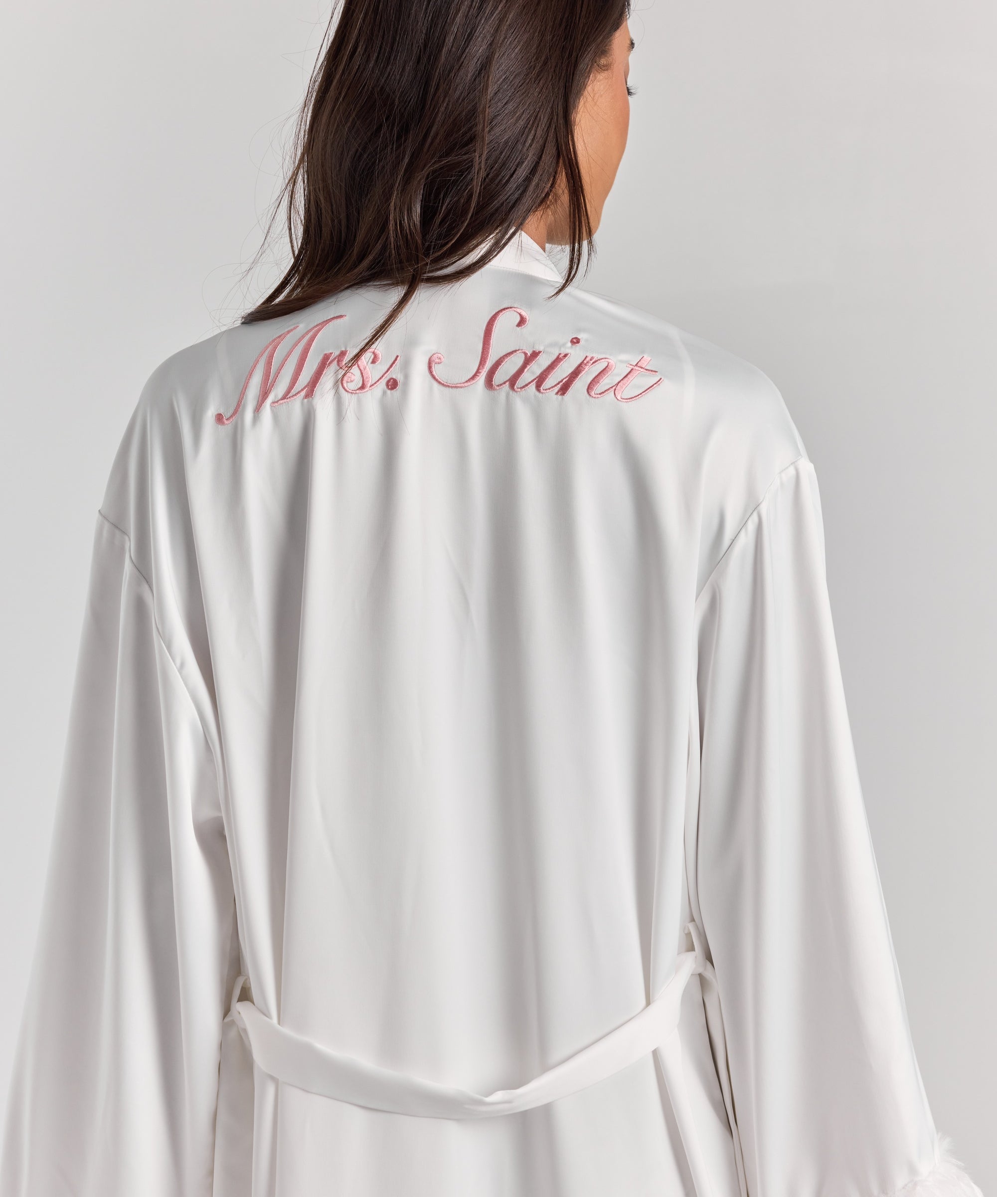 White Melita feather satin robe from behind, with personalized embroidery across the upper back, a self-tie belt and feather cuffs.