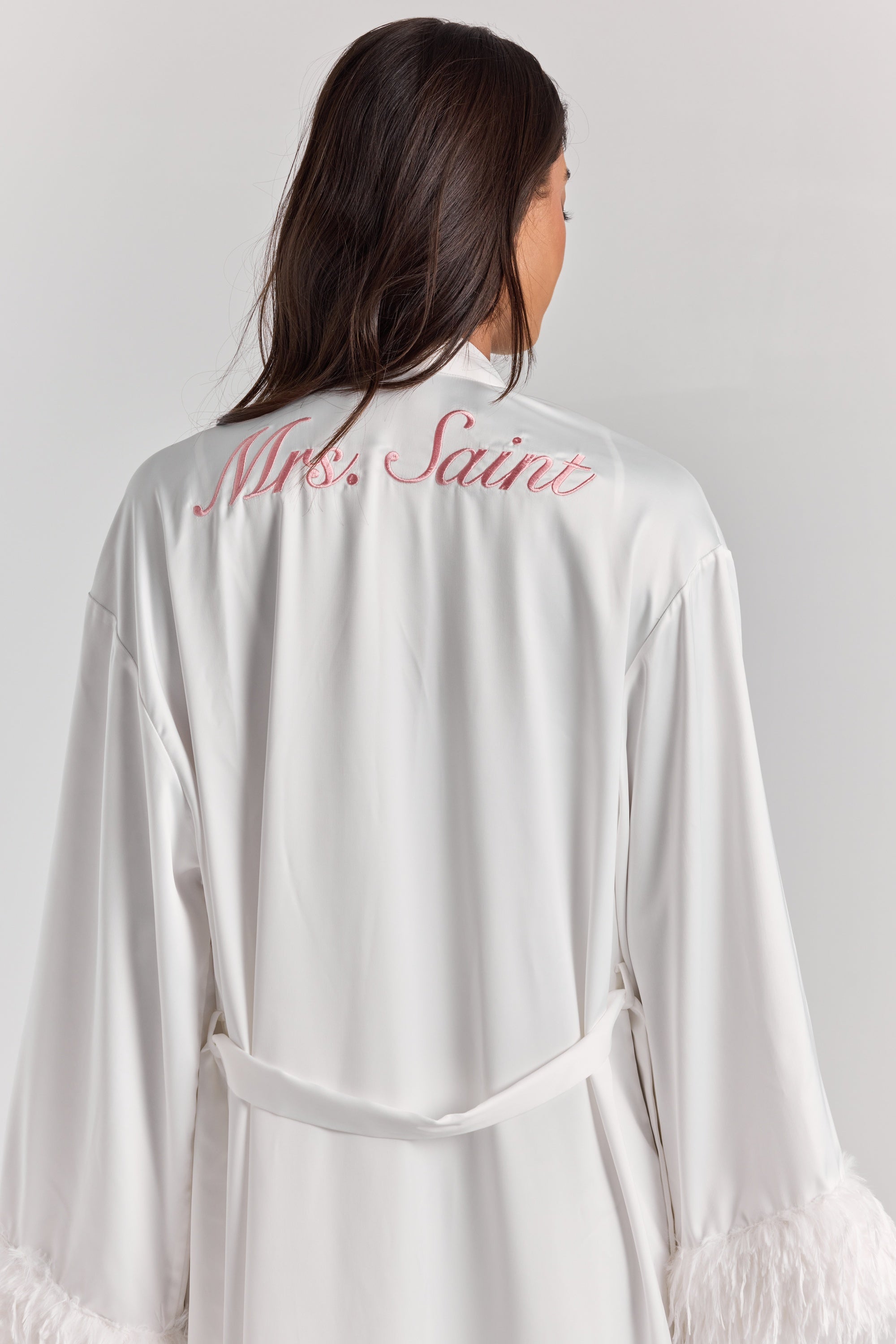 White Melita feather satin robe from behind, with personalized embroidery across the upper back, a self-tie belt and feather cuffs.