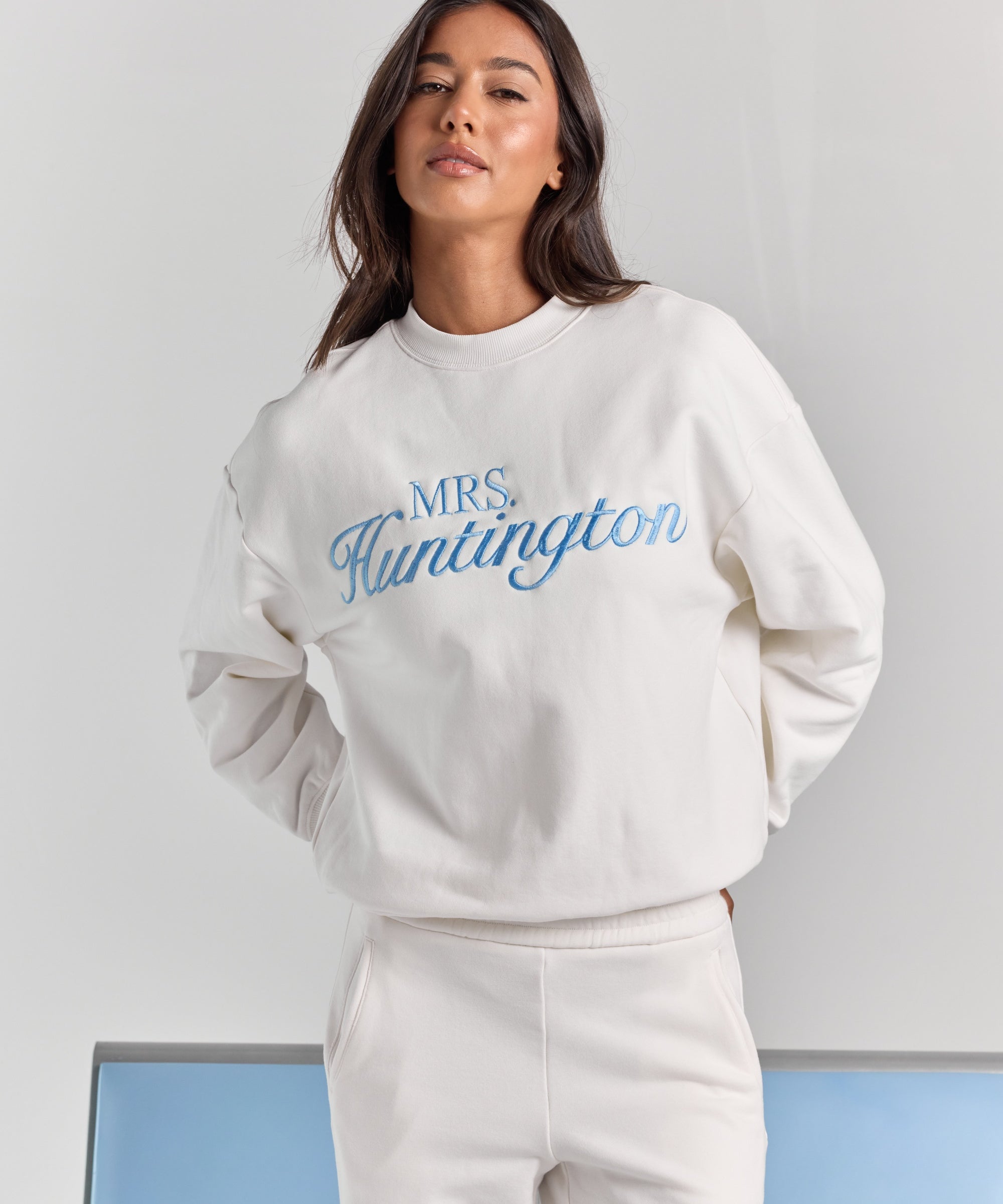 White Pia crew sweatshirt from the front, oversized through the body and sleeves, with personalized embroidery across the chest.