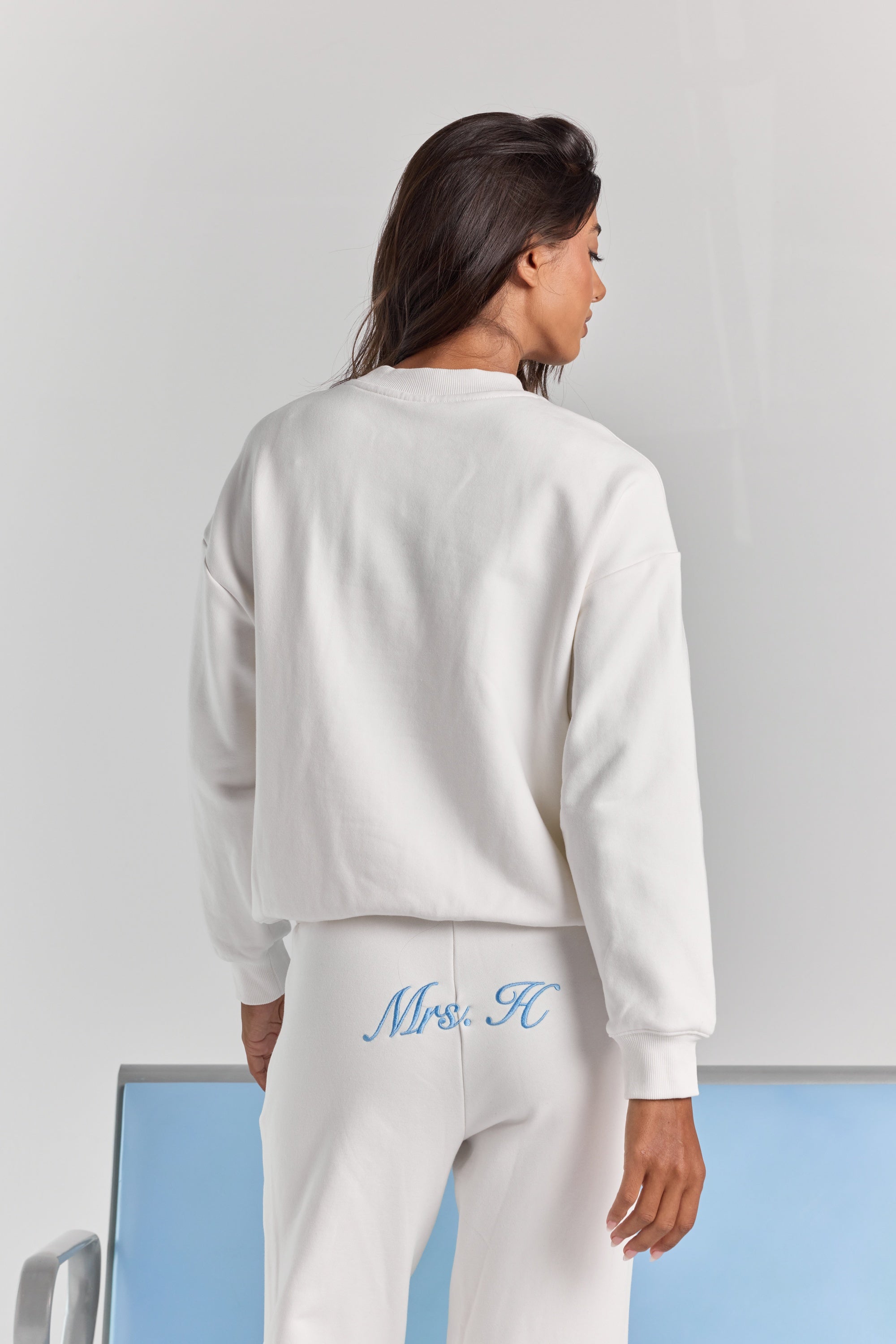 White Pia crew sweatshirt from behind, plain across the back with dropped shoulders, a ribbed neckline and ribbed cuffs.