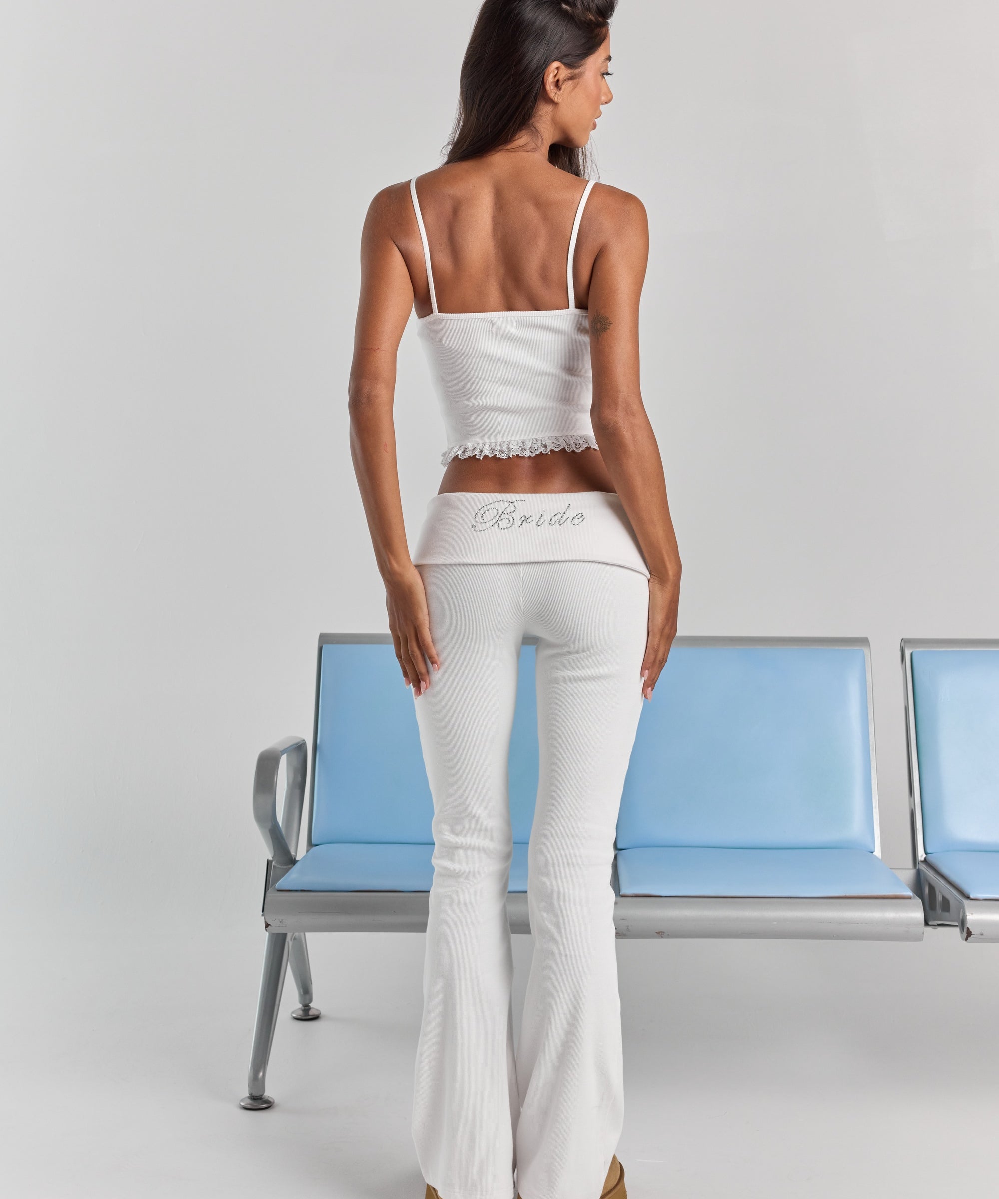 White Rhinestone Frankie foldover ribbed pant from behind, with Bride in rhinestones across the folded waistband and a flared leg.