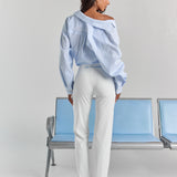 White Vivienne travel pant from behind, with personalized embroidery just below the back waistband and a straight leg.