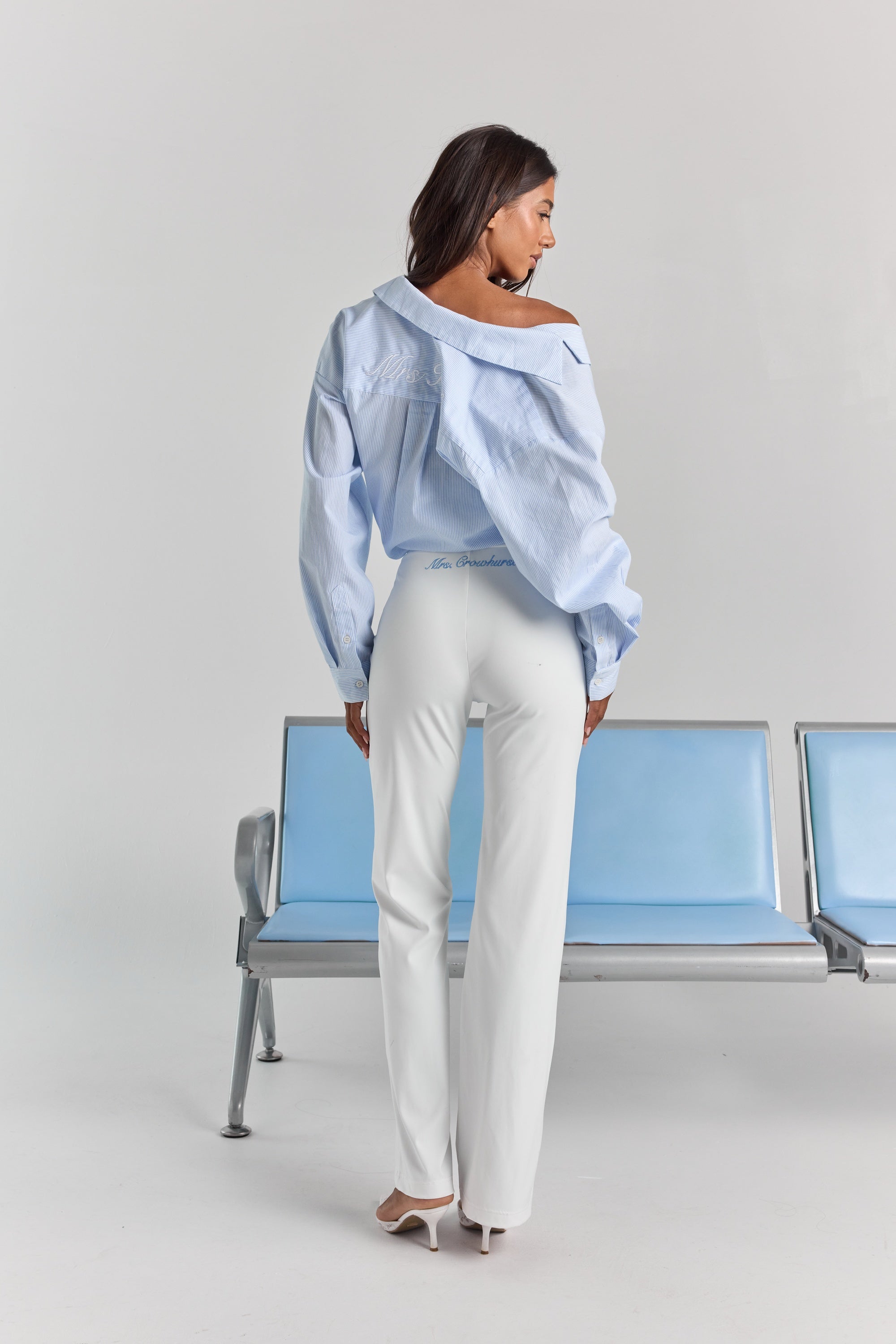 White Vivienne travel pant from behind, with personalized embroidery just below the back waistband and a straight leg.