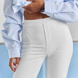 A close-up of the flat waistband and stitched mock fly at the front of the white Vivienne travel pant.