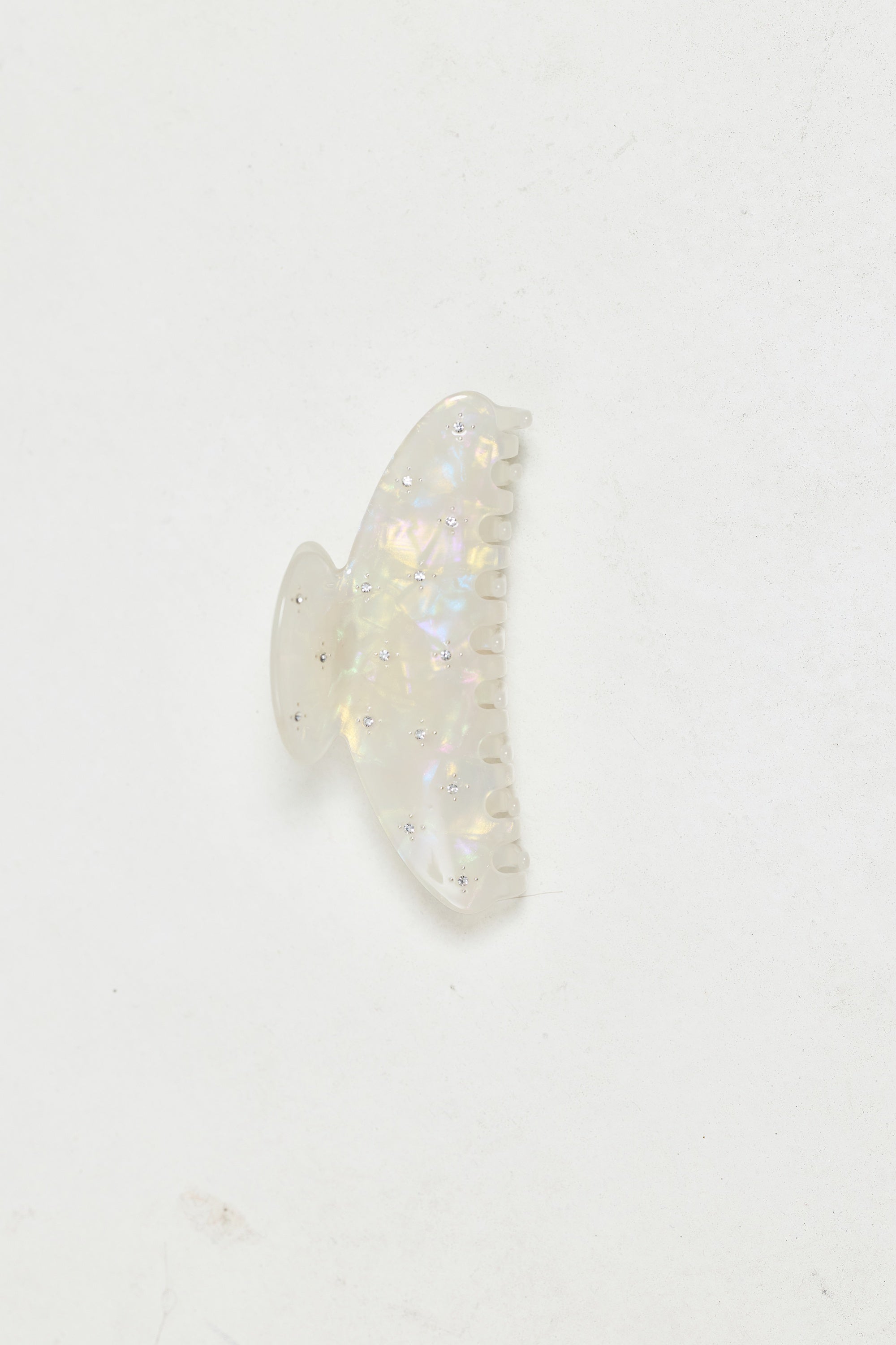 ALT's iridescent Gia claw clip, a product shot of the shifting pink and green finish scattered with rhinestones.