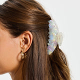 ALT's iridescent Gia claw clip, worn in the hair from the side, the iridescent finish catching the light.