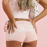 A close-up of the Diva rhinestone script across the seat of ALT's pink Princess rhinestone velour short.