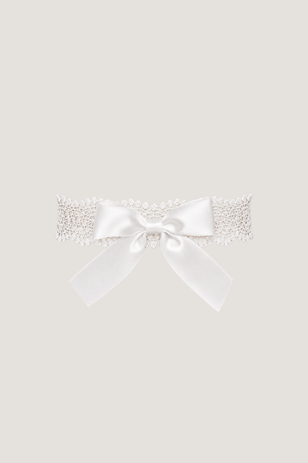 ALT's white Lea bow garter, a product shot of the guipure lace band finished with an oversized satin bow.
