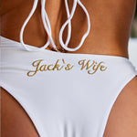 Woman wearing ALT’s Elidy one piece, a white bridal one piece swimsuit with gold chain halter detailing, back tie and gold embroidery Jack's Wife