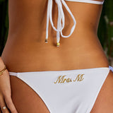 Woman wearing ALT’s Kala top and Faya bottom, a white bridal bikini set, with cactus behind her. Small satin bow and satin binding. Gold embroidery on the back of bottoms Mrs. M
