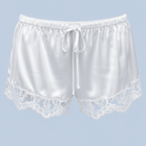 White Gianna satin lace short shown on its own from the front, with a drawstring tie, elasticated waist and floral lace at each leg.