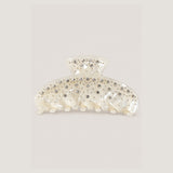 ALT's ivory Kelly claw clip, a product shot of the pearlescent face scattered with rhinestones and silver studs.