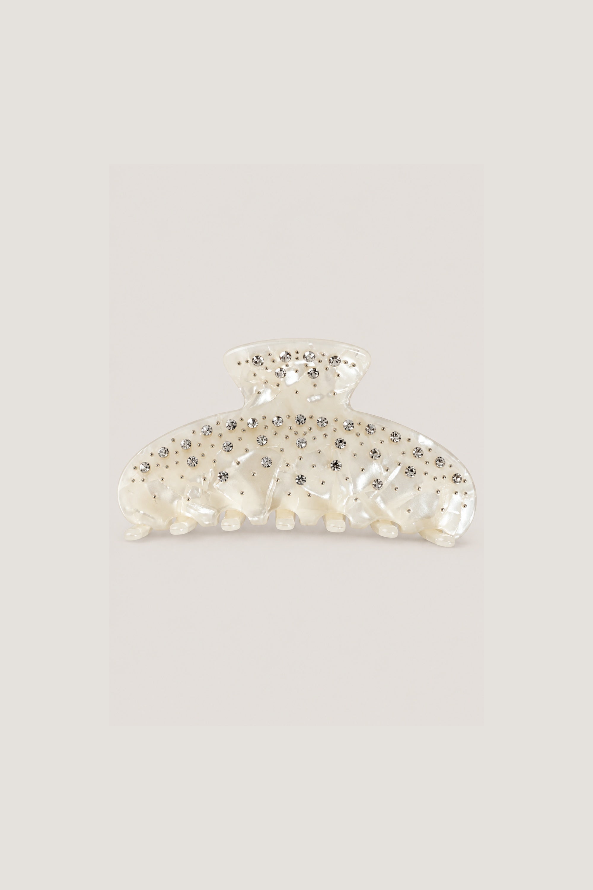 ALT's ivory Kelly claw clip, a product shot of the pearlescent face scattered with rhinestones and silver studs.