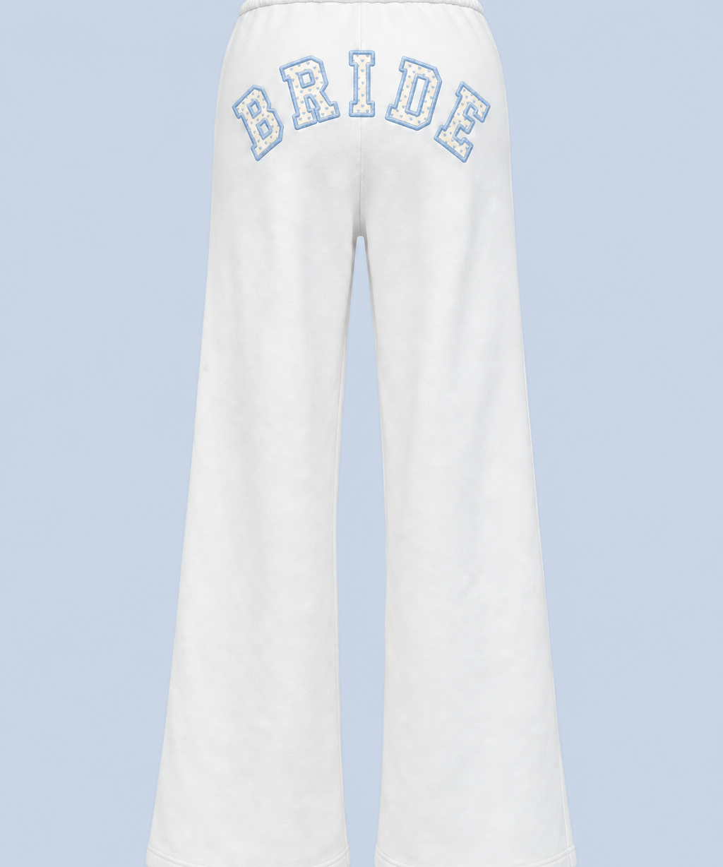 ALT's white Bride Paola trackpant shown on its own from behind, with BRIDE in blue-outlined varsity applique arched high across the back.