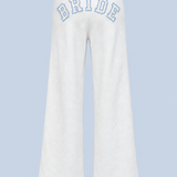 ALT's white Bride Paola trackpant shown on its own from behind, with BRIDE in blue-outlined varsity applique arched high across the back.