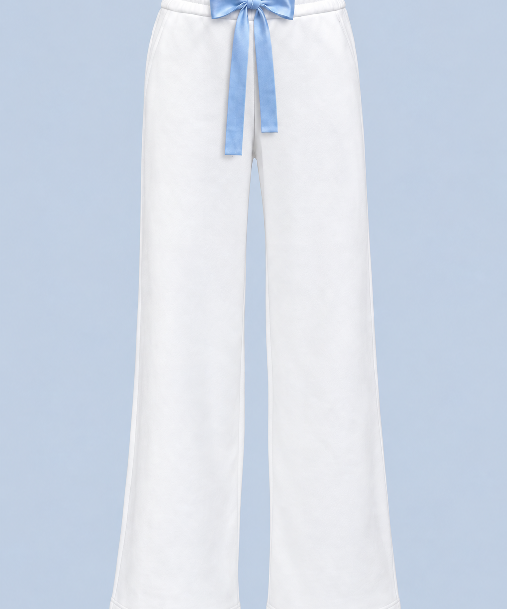 White Bride Paola trackpant shown on its own from the front, with a blue satin bow tied at the elasticated waist and a wide straight leg.